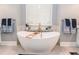 Bright bathroom featuring a luxurious white soaking tub with a wooden bath caddy and a window with shutter blinds at 3045 Camp Branch Rd, Buford, GA 30519