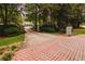 Brick-paved driveway leading to a property surrounded by lush greenery and mature trees at 3045 Camp Branch Rd, Buford, GA 30519
