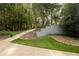 Concrete driveway with manicured landscaping and a retaining wall at 3045 Camp Branch Rd, Buford, GA 30519