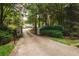 Long driveway leading to a lovely home surrounded by lush greenery and mature trees at 3045 Camp Branch Rd, Buford, GA 30519