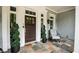 Close up of covered front porch with decorative plants and a chair for relaxation at 3045 Camp Branch Rd, Buford, GA 30519