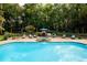 A backyard oasis featuring a swimming pool, stone-accented hot tub, lush landscaping, and comfortable lounge seating at 3045 Camp Branch Rd, Buford, GA 30519