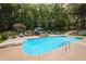 An inviting swimming pool area with stone accents, a diving board, and an outdoor dining setup, creating a relaxing oasis at 3045 Camp Branch Rd, Buford, GA 30519