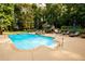 Relaxing pool area with a diving board, stone hot tub, and outdoor lounge chairs in a serene, wooded setting at 3045 Camp Branch Rd, Buford, GA 30519