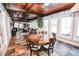 Bright sunroom with wood ceiling, brick accents, dining area, and comfortable seating area at 3045 Camp Branch Rd, Buford, GA 30519