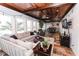 Bright sunroom with wood ceiling, brick accents, multiple windows, and comfortable seating area at 3045 Camp Branch Rd, Buford, GA 30519