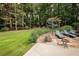 Stone patio with lounge chairs next to landscaped garden and manicured lawn at 3045 Camp Branch Rd, Buford, GA 30519