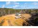 Wide aerial shot capturing the home and outbuildings nestled within acres of sprawling land and mature trees at 511 Monroe Cole Rd, Dallas, GA 30157