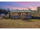 Charming exterior featuring a covered porch and a metal roof, set on a large lot with mature trees at 511 Monroe Cole Rd, Dallas, GA 30157