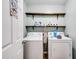 Laundry room with washer, dryer, shelving and natural colored laminate flooring for convenience at 511 Monroe Cole Rd, Dallas, GA 30157