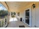 Covered porch featuring wood flooring and a white railing with a view of the surrounding trees at 511 Monroe Cole Rd, Dallas, GA 30157