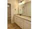 Bathroom vanity featuring granite countertops, white cabinetry, and a decorative mirror with elegant lighting fixtures above at 1685 Crumbley Rd, Mcdonough, GA 30252