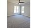 Bedroom features plush carpeting, two windows, and a ceiling fan at 1685 Crumbley Rd, Mcdonough, GA 30252