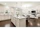 Open-concept kitchen with a large island, white cabinets, stainless steel appliances, and a view into the living area at 170 Wheaten Dr, Woodstock, GA 30188
