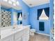 Bright blue bathroom with a single sink vanity, toilet, and shower/tub combo at 1800 Rockdale Cir, Snellville, GA 30078