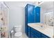 The bathroom features a toilet, sink, mirror, vanity, countertop, and a combination of blue cabinetry and white walls at 1800 Rockdale Cir, Snellville, GA 30078