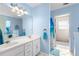 Well-lit bathroom with double sinks, a large mirror, and blue accent colors at 1800 Rockdale Cir, Snellville, GA 30078