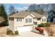 Attractive home featuring vinyl siding, attached garage, manicured hedges, and a stone entryway at 1800 Rockdale Cir, Snellville, GA 30078