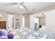 Comfortable carpeted main bedroom featuring a ceiling fan, ensuite bathroom and large doorway into another bonus room at 1800 Rockdale Cir, Snellville, GA 30078
