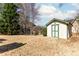 Exterior view of a backyard shed with white siding, green trim, and double doors, providing outdoor storage at 1800 Rockdale Cir, Snellville, GA 30078