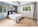 Bright bedroom featuring hardwood floors, an accent wall, and large windows with natural lighting at 2751 Margaret Mitchell Nw Dr, Atlanta, GA 30327