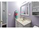 Bathroom vanity with modern fixtures, lavender walls, and a decorative towel at 935 Sunset Ridge Ln, Lawrenceville, GA 30045