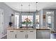 Bright kitchen features a granite island, white cabinetry, stainless steel appliances, and modern pendant lighting at 935 Sunset Ridge Ln, Lawrenceville, GA 30045