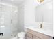Modern bathroom featuring a glass shower, marble-style tiling, and vanity with neutral wood tones and gold hardware at 245 Mayfair Ct, Alpharetta, GA 30009