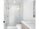 Bathroom featuring a glass shower, marble-style tiling, and vanity with neutral wood tones and gold hardware at 245 Mayfair Ct, Alpharetta, GA 30009