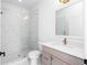 Modern bathroom featuring a glass shower, marble-style tiling, and vanity with neutral wood tones and gold hardware at 245 Mayfair Ct, Alpharetta, GA 30009