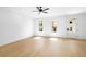 Bright, spacious bedroom with wood floors, ceiling fan, white trim, and doors leading to the outside at 245 Mayfair Ct, Alpharetta, GA 30009