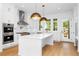 Spacious white kitchen featuring stainless steel appliances, a gas cooktop, and a large center island with white countertops at 245 Mayfair Ct, Alpharetta, GA 30009
