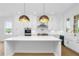 Bright kitchen boasts white cabinets, stainless steel appliances, and a large island with pendant lighting at 245 Mayfair Ct, Alpharetta, GA 30009