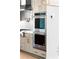 Double stainless steel ovens and light brown cabinets, paired with white backsplash tiles and countertops at 245 Mayfair Ct, Alpharetta, GA 30009