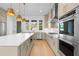 Modern kitchen with a large island, stainless steel appliances, and stylish pendant lighting over hardwood floors at 245 Mayfair Ct, Alpharetta, GA 30009