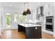 Modern kitchen features a dark island, stainless steel appliances, and a door leading to the backyard at 245 Mayfair Ct, Alpharetta, GA 30009