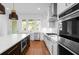 Modern kitchen features stainless steel appliances, a dark island, and a view of the backyard at 245 Mayfair Ct, Alpharetta, GA 30009