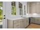 Modern kitchen with light brown cabinets, stainless steel appliances, white countertops, and a view to the outside greenery at 245 Mayfair Ct, Alpharetta, GA 30009