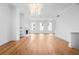 Open-concept living space featuring hardwood floors, a fireplace, built-in shelving, and contemporary chandelier at 245 Mayfair Ct, Alpharetta, GA 30009