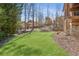 Expansive backyard with lush green grass, mature trees, and play area at 5640 Copper Creek Pass, Cumming, GA 30040