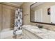 Bathroom featuring a granite countertop vanity and a shower-tub combo with a patterned shower curtain at 5640 Copper Creek Pass, Cumming, GA 30040