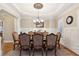 Formal dining room with elegant chandelier, decorative molding, and hardwood floors at 5640 Copper Creek Pass, Cumming, GA 30040