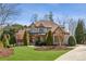 Stunning brick home featuring a well-manicured lawn, mature trees, and a classic architectural design at 5640 Copper Creek Pass, Cumming, GA 30040