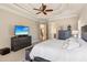 Spacious main bedroom with tray ceilings, ceiling fan, an ensuite bathroom, and a large television at 5640 Copper Creek Pass, Cumming, GA 30040