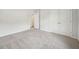 This bedroom features neutral carpeting and paint, and a double-door closet at 1452 Stephens View Dr, Loganville, GA 30052