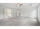 This main bedroom features neutral carpeting, a ceiling fan and an ensuite bathroom at 1452 Stephens View Dr, Loganville, GA 30052