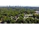 An aerial shot of the 321 Dilbeck property surrounded by mature trees and a view of the city skyline at 321 Dilbeck Ne Cir, Atlanta, GA 30342
