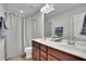 Bathroom featuring dual sinks, a vanity with wood cabinets, and a mirror at 4165 Azurite St, Cumming, GA 30040