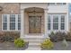 Inviting front entrance with double doors, columns, and meticulously landscaped garden beds at 4165 Azurite St, Cumming, GA 30040