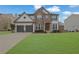 Charming two-story home featuring a large front lawn, brick facade, and attached two-car garage at 4165 Azurite St, Cumming, GA 30040